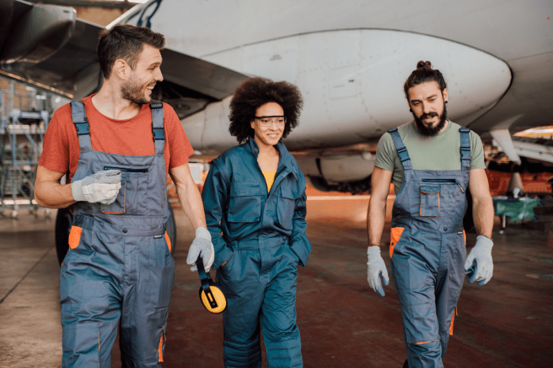 Three aerospace recruitment workers smile and have a discussion while walking through the jobsite.