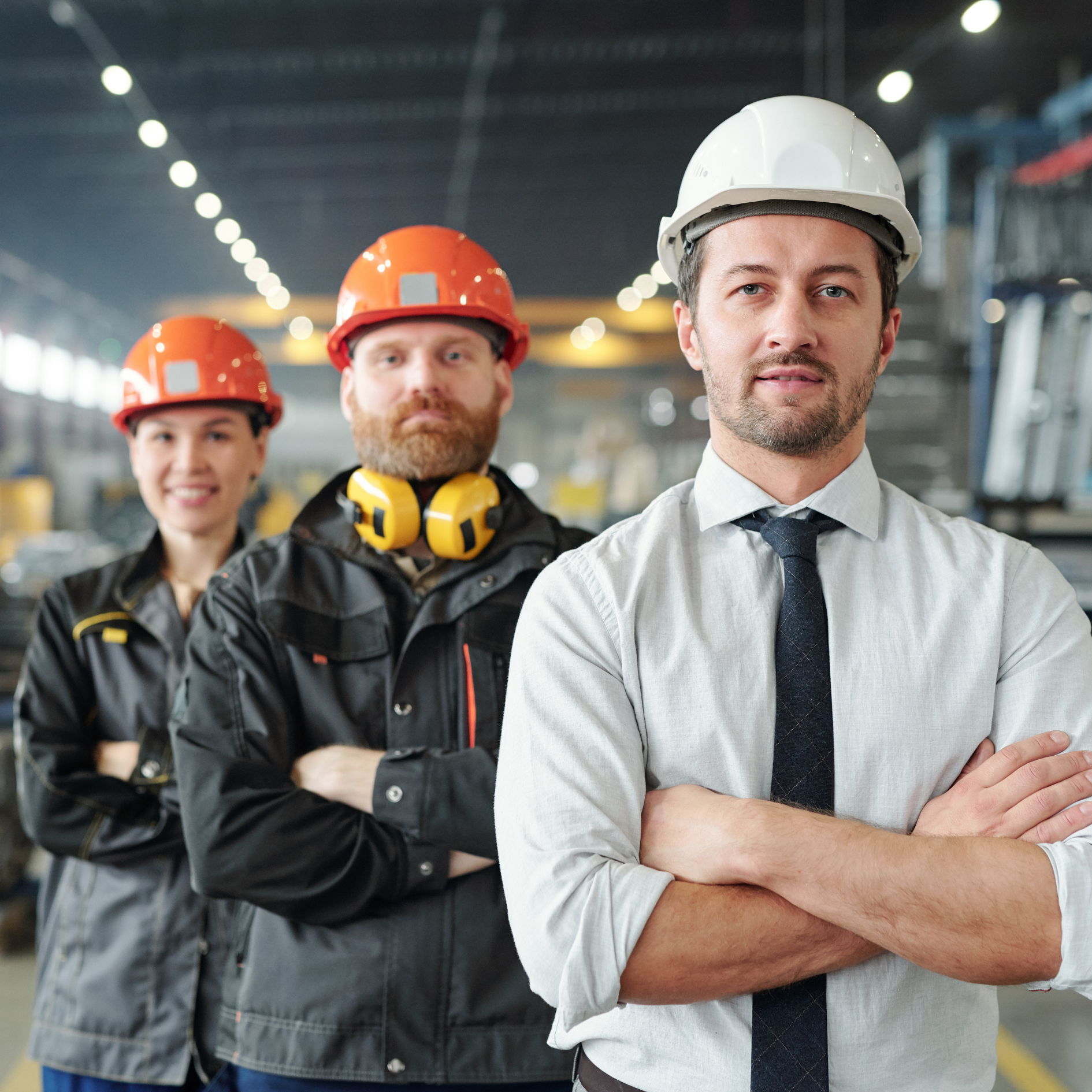 HIDDEN TALENT A light industrial staffing hire wearing a hardhat carries a large plank of wood.